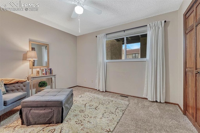 living area with light colored carpet, visible vents, a textured ceiling, and baseboards