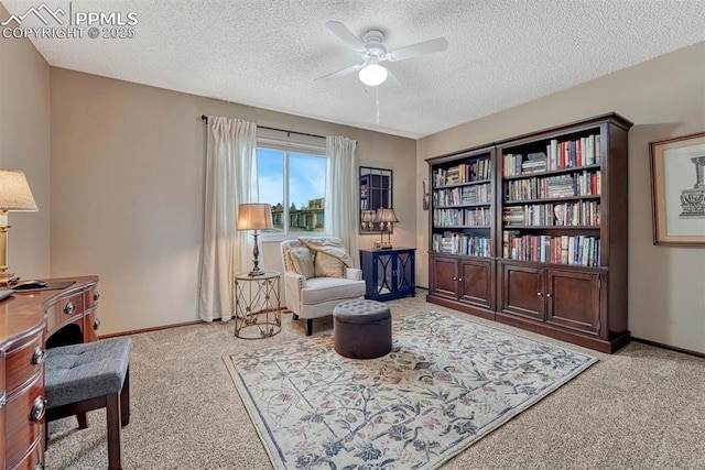 sitting room with a ceiling fan, carpet flooring, a textured ceiling, and baseboards