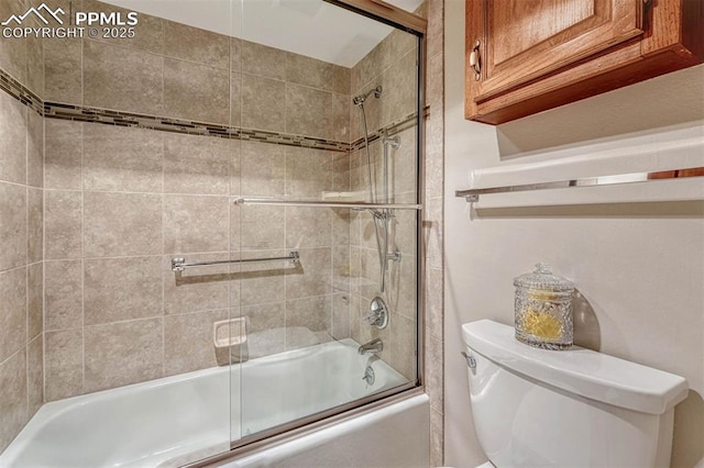 bathroom featuring enclosed tub / shower combo and toilet