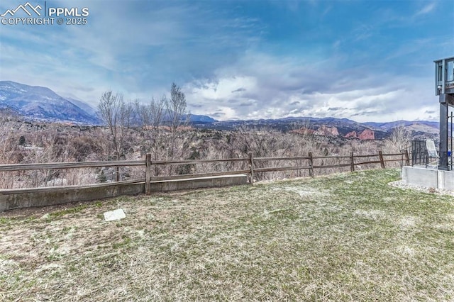 view of yard with fence and a mountain view