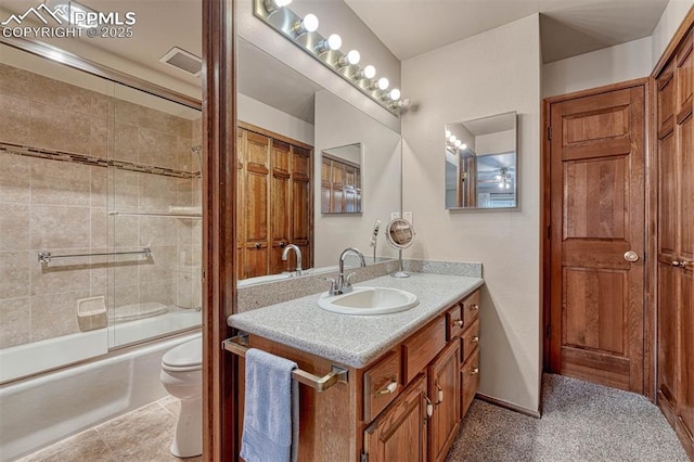 bathroom featuring toilet, tile patterned floors, bath / shower combo with glass door, and vanity