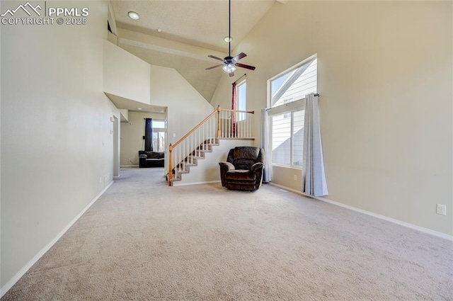 unfurnished room featuring carpet floors, stairway, high vaulted ceiling, and a wealth of natural light