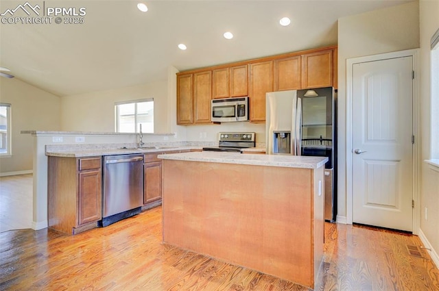 kitchen with a kitchen island, stainless steel appliances, and brown cabinets