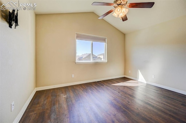 empty room with baseboards, vaulted ceiling, wood finished floors, and a ceiling fan