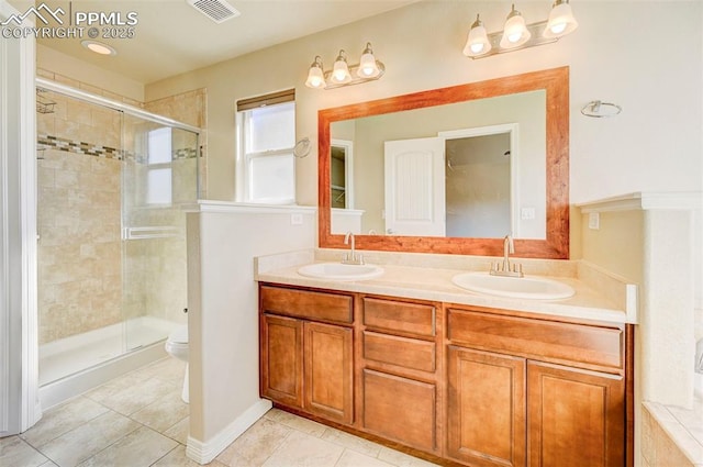 full bath with visible vents, a sink, a stall shower, and toilet
