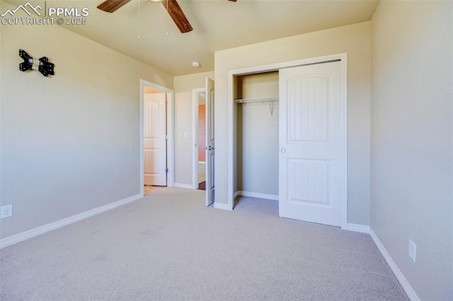 unfurnished bedroom featuring baseboards, a closet, light colored carpet, and a ceiling fan