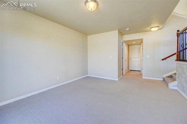 unfurnished living room with baseboards, light colored carpet, and stairway