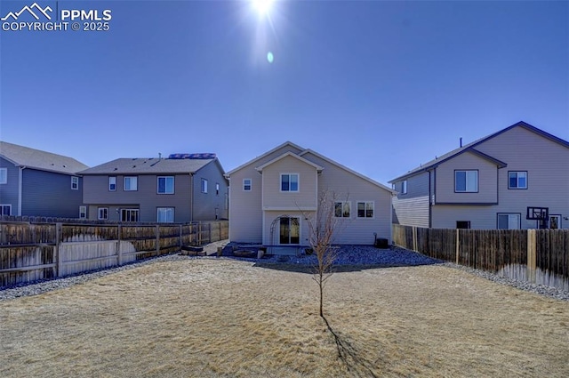 rear view of house featuring a fenced backyard and a residential view