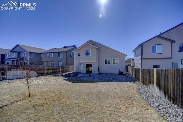 back of house featuring a fenced backyard and a residential view
