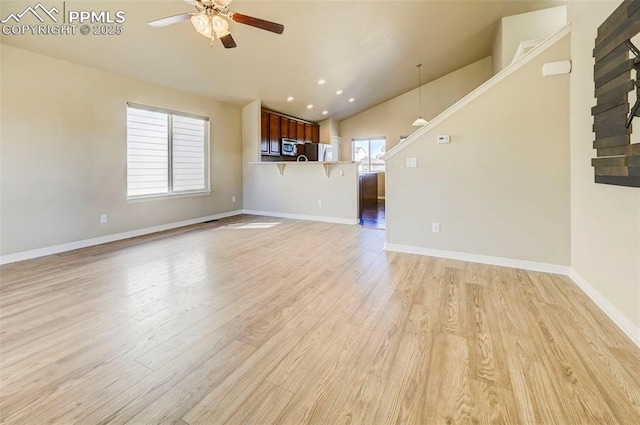 unfurnished living room with a ceiling fan, lofted ceiling, light wood-style flooring, baseboards, and recessed lighting