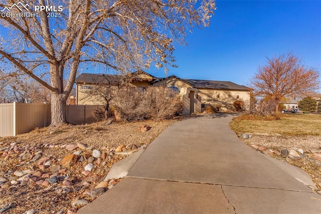 view of front facade with driveway and fence