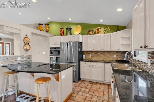 kitchen featuring lofted ceiling, appliances with stainless steel finishes, open shelves, and a sink