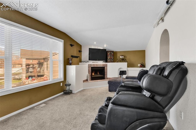 living room with a fireplace, visible vents, carpet flooring, vaulted ceiling, and baseboards