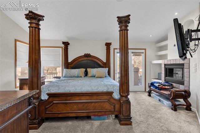 carpeted bedroom with decorative columns, a fireplace, and recessed lighting