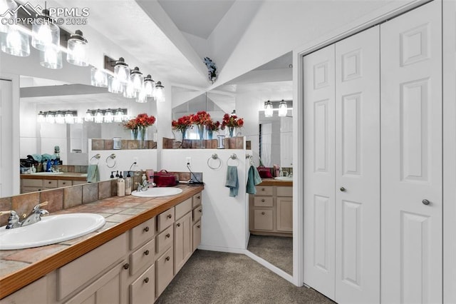 bathroom featuring double vanity, a closet, and a sink