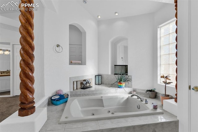 full bathroom with a jetted tub and vanity