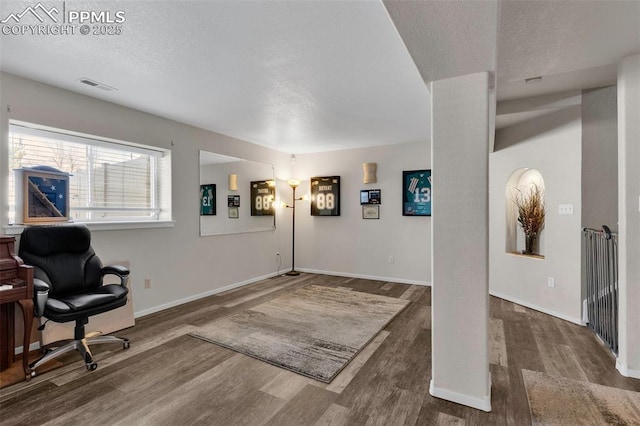 foyer entrance featuring visible vents, a textured ceiling, baseboards, and wood finished floors