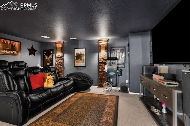 carpeted home theater with a textured ceiling, a textured wall, and decorative columns