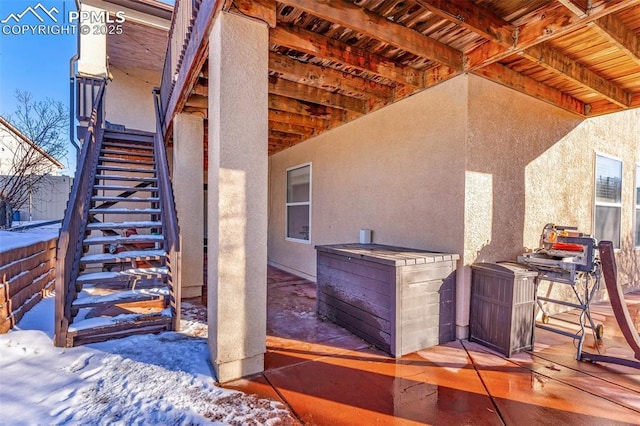 snow covered patio with stairs