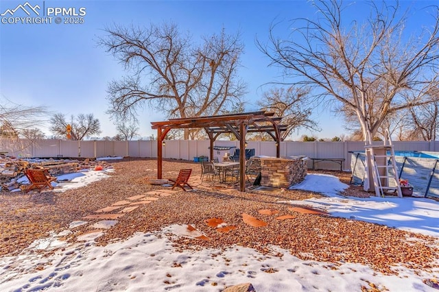 snowy yard featuring a patio area, a fenced backyard, and a pergola