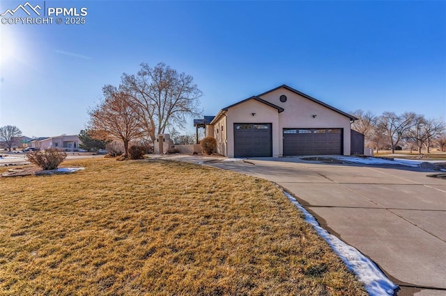 view of property exterior with driveway, a yard, an attached garage, and stucco siding