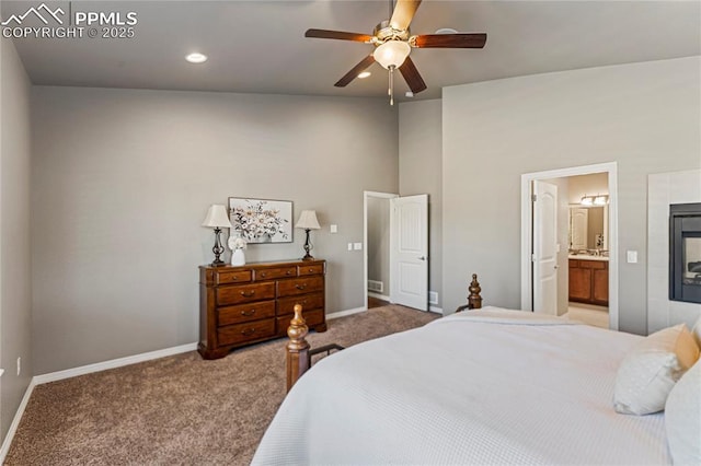 bedroom with ensuite bath, a fireplace, baseboards, and light colored carpet