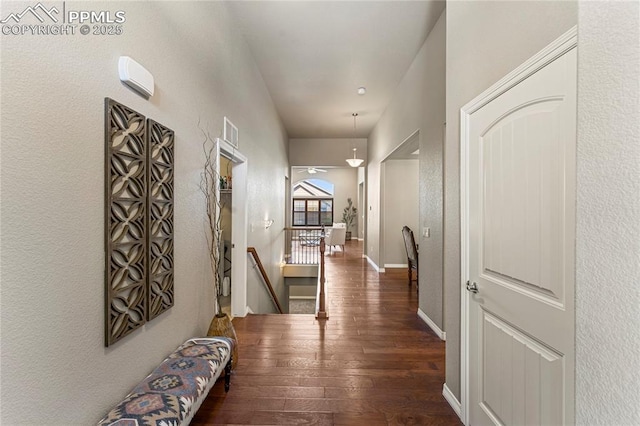 corridor with visible vents, wood-type flooring, an upstairs landing, and baseboards