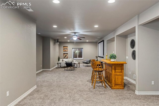 bar with light carpet, a bar, baseboards, and recessed lighting