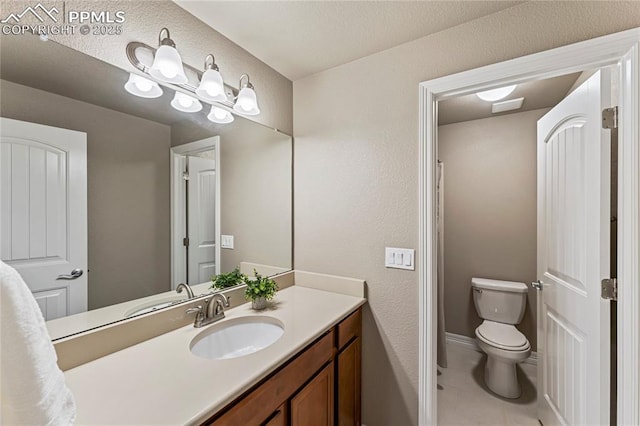 bathroom with vanity, toilet, and tile patterned floors