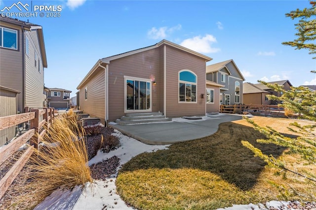 rear view of house featuring entry steps, a yard, a patio, and fence