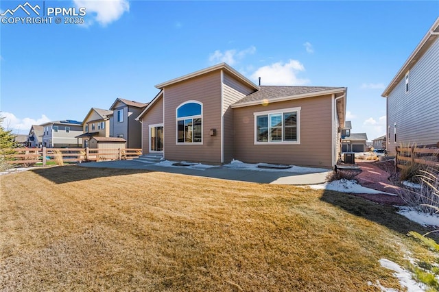 back of property with entry steps, a lawn, a patio, and fence