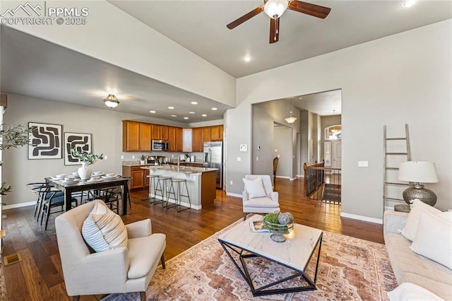 living area featuring baseboards, dark wood-type flooring, and recessed lighting