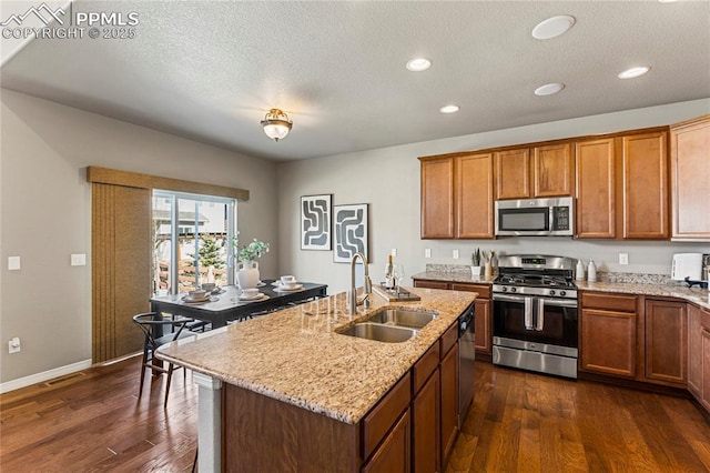 kitchen with visible vents, appliances with stainless steel finishes, dark wood-style flooring, and a sink