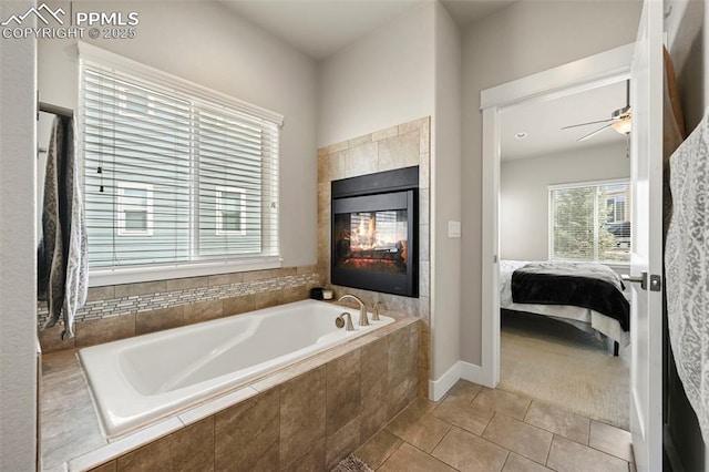 bathroom featuring a garden tub, a tiled fireplace, ensuite bathroom, a ceiling fan, and tile patterned flooring