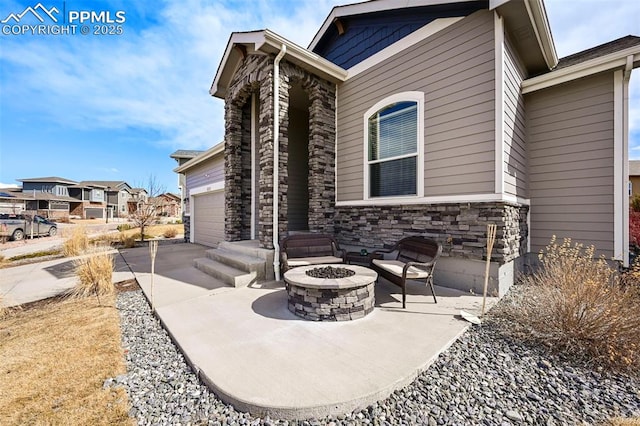 view of patio / terrace featuring driveway and a fire pit