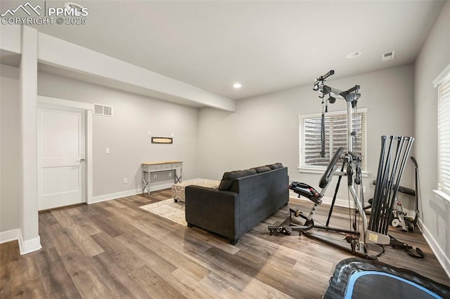 exercise area with baseboards, visible vents, wood finished floors, and recessed lighting