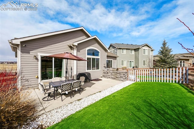 rear view of house featuring a yard, a patio area, and fence