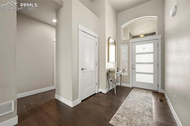 entrance foyer featuring baseboards, visible vents, and dark wood-style flooring