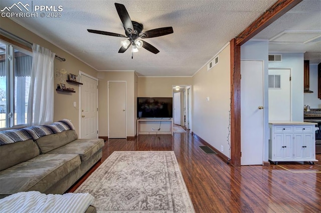 unfurnished living room featuring dark wood-style floors, a textured ceiling, visible vents, and a ceiling fan