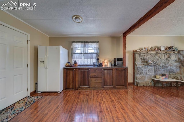 bar featuring a textured ceiling, white fridge with ice dispenser, ornamental molding, and wood finished floors