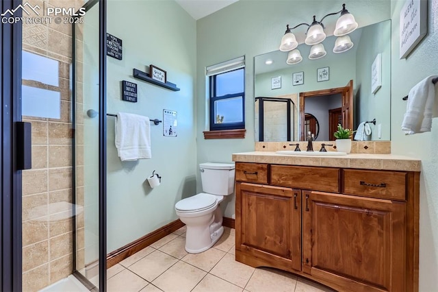 bathroom with baseboards, toilet, tile patterned flooring, vanity, and a shower stall