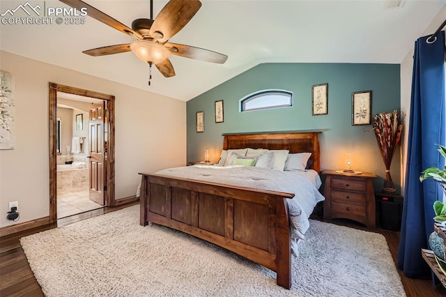 bedroom with baseboards, lofted ceiling, ensuite bath, ceiling fan, and wood finished floors