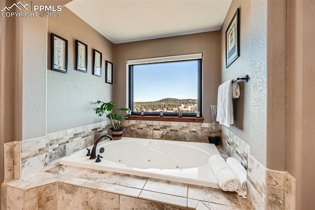 bathroom with a textured wall and a whirlpool tub