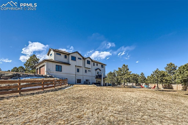 back of property with fence and stucco siding