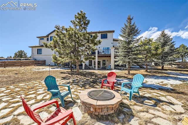 view of patio / terrace with a balcony, an outdoor fire pit, and fence