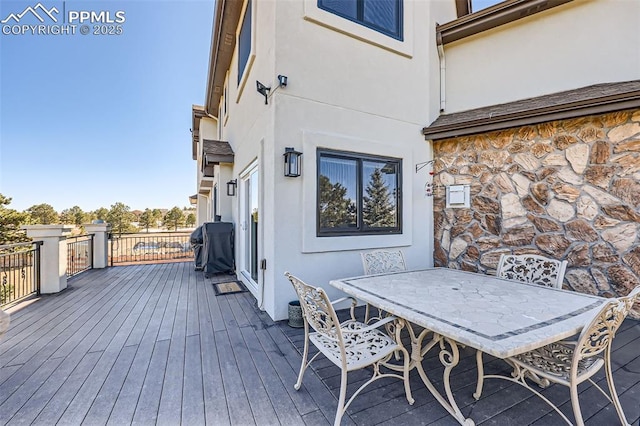 wooden deck featuring a grill and outdoor dining area