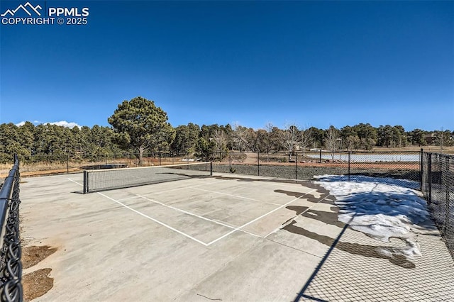 view of tennis court featuring fence