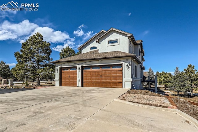 view of front facade with driveway, a garage, and stucco siding