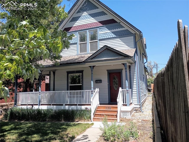 victorian house with covered porch and fence