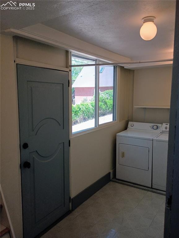 laundry room featuring a textured ceiling, laundry area, independent washer and dryer, and baseboards